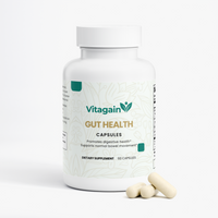 A white bottle of Vitagain Gut Health dietary supplement capsules with three capsules placed in front on a clean white background.
